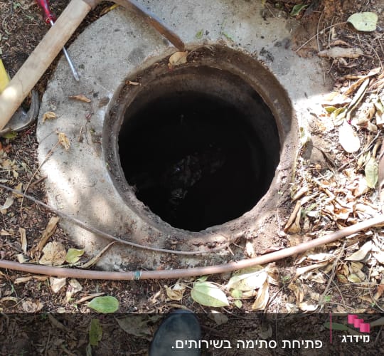 בור ביוב פתוח עם כלי עבודה מסביב